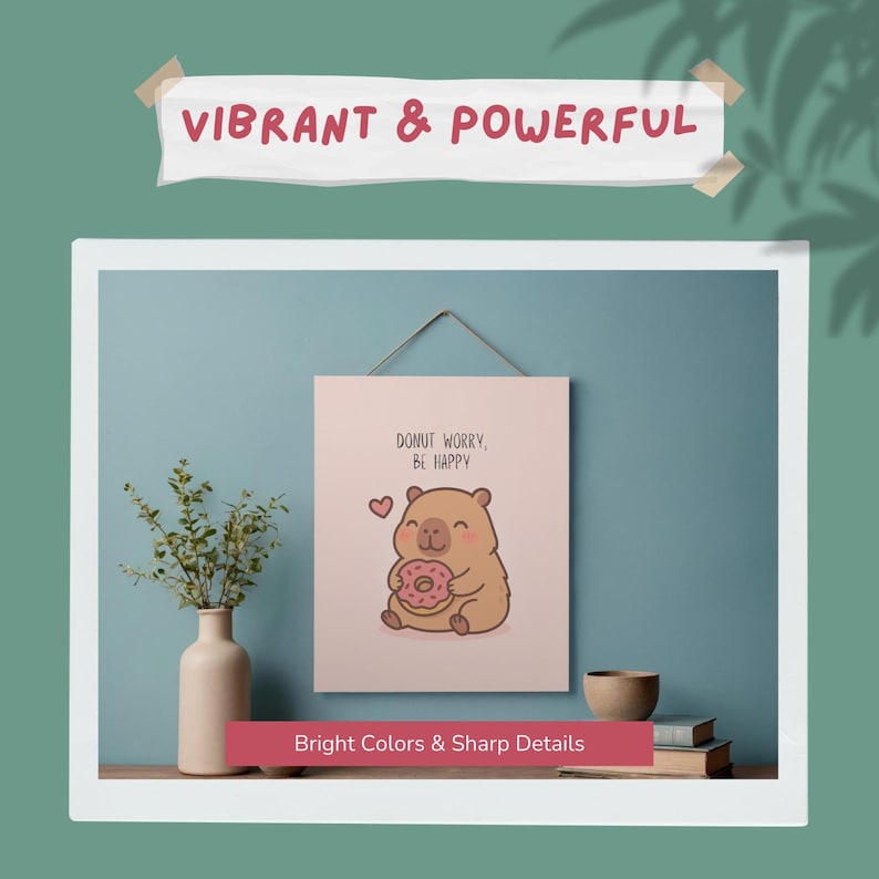 May include: A framed print with a cute cartoon bear holding a donut, with the text "DONUT WORRY, BE HAPPY." The print is displayed on a blue wall. The words "VIBRANT & POWERFUL" and "Bright Colors & Sharp Details" are also visible.