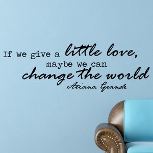 Può includere: Un adesivo da parete con una citazione di Ariana Grande: "Se diamo un po' d'amore, forse possiamo cambiare il mondo".