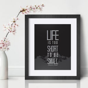 May include: A black and white framed print with a motivational quote: "Life is too short to be small." The quote is attributed to "Benjamin Disraeli" and is set against a dark grey background with a mountain range silhouette.