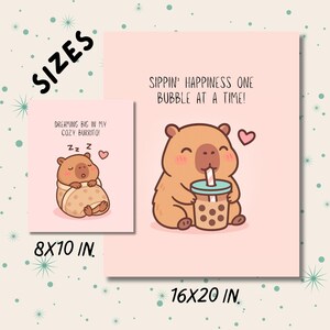 May include: Two pink art prints with cartoon capybaras. One shows a sleeping capybara wrapped in a blanket, the other a capybara sipping bubble tea. The sizes are 8x10 inches and 16x20 inches.
