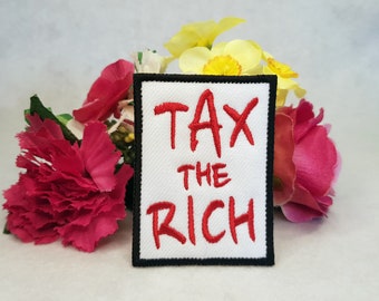May include: White fabric patch with black border and red embroidered text that reads "Tax the Rich".