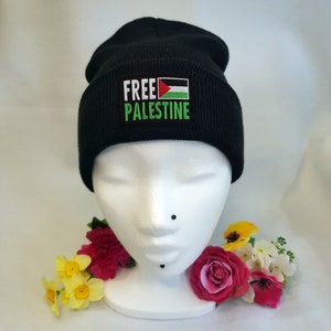 May include: Black beanie with a green, white, and red Palestinian flag and the text "FREE PALESTINE" embroidered on the front.