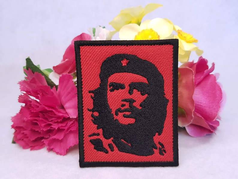 Pu&ograve; includere: Una toppa ricamata rossa con una silhouette nera di Che Guevara che indossa un berretto rosso con una stella.