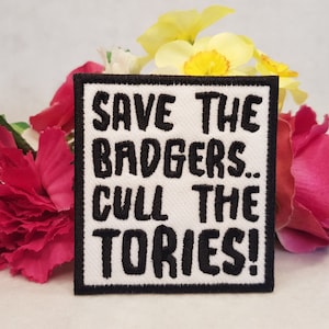 Pode incluir: Etiqueta branca bordada com texto preto que diz "Save the Badgers... Cull the Tories!"