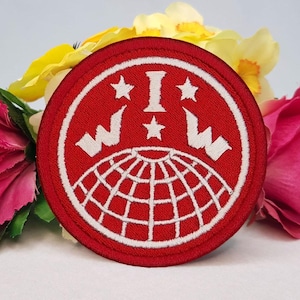 May include: Red embroidered patch with a white globe, stars, and the letters "W.I.W." in a circle.