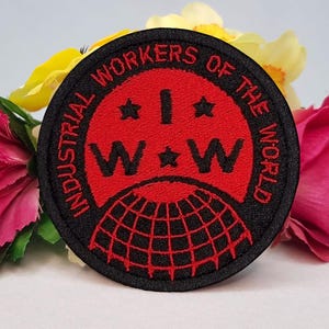 Puede incluir: Parche bordado negro y rojo con el texto "Industrial Workers of the World" y las letras "IWW" en un círculo rojo con estrellas.