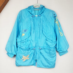 May include: A turquoise hooded jacket with a zipper closure, drawstring waist, and two front pockets. The jacket features embroidered starfish and aquatic designs, with "WORLD" in yellow lettering on the sleeve. The jacket is hanging on a white hanger.