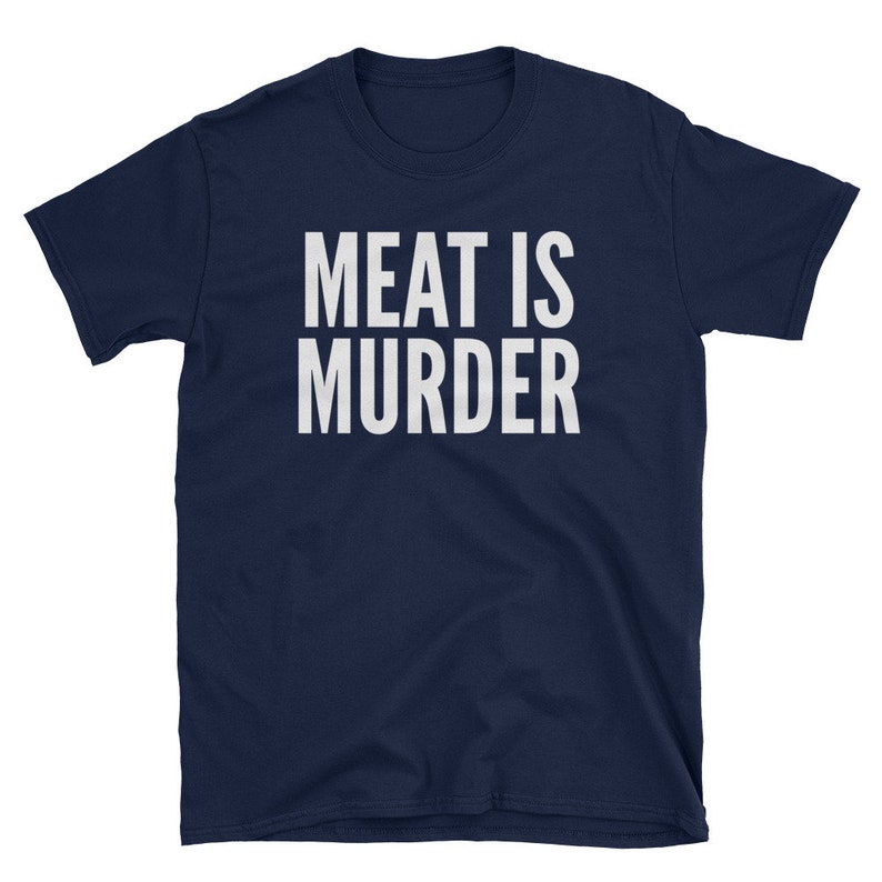 Puede incluir: Camiseta azul marino con el texto blanco "MEAT IS MURDER" en una fuente en negrita sin serifa. La camiseta, de manga corta y cuello redondo, probablemente est&aacute; hecha de algod&oacute;n o un tejido similar, y se muestra sobre un fondo blanco.