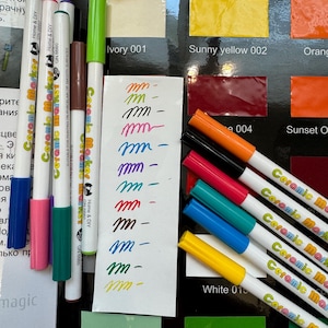 以下が含まれることがあります： 白いバレルと色のついたキャップが付いたセラミックマーカーのセットです。マーカーはキャップが視聴者の方を向いている状態で一列に並んでいます。マーカーの色は、ピンク、グリーン、ブラウン、パープル、レッド、ブラック、ターコイズ、ブルー、イエロー、ホワイトです。マーカーには「Ceramic Marker」と「Home & DIY」の文字が書かれています。