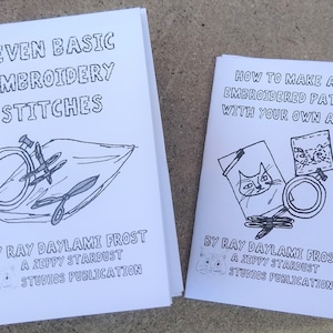 Peut inclure: Deux zines illustrés en noir et blanc, l'un intitulé "Seven Basic Embroidery Stitches" et l'autre intitulé "How to Make an Embroidered Patch with Your Own Art." Les deux zines sont de Ray Daylami Frost, une publication de Zeppy Stardust Studios.