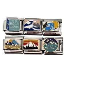 May include: A set of six silver charm bracelets with colorful enamel charms featuring mountain and camping themes. The charms include a book with the text "Book Worm", a wave, a tent, a mountain range with the text "Explore", a mountain range with a sunset, and a mountain range with a crescent moon and the text "To the Mountain".