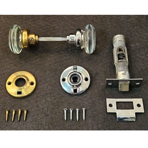 May include: A set of antique door hardware with glass knobs, a brass backplate, and a chrome latch. The set includes screws for installation.