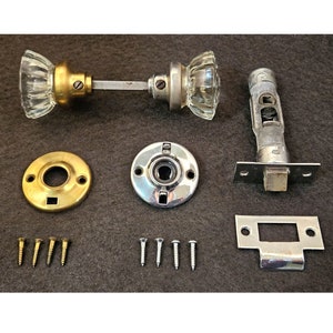 May include: A set of antique door hardware with glass knobs, brass and chrome plates, a latch, and screws.