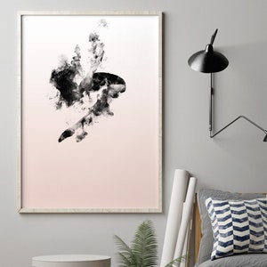 May include: A framed black and white abstract art print of a dancer in mid-air, with a pink gradient background. The print is hanging on a white wall, with a gray couch, a potted plant, and a lamp in the background.