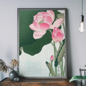 May include: A vintage Japanese woodblock print featuring a pink lotus flower with green leaves. The print is framed in a dark wood frame.