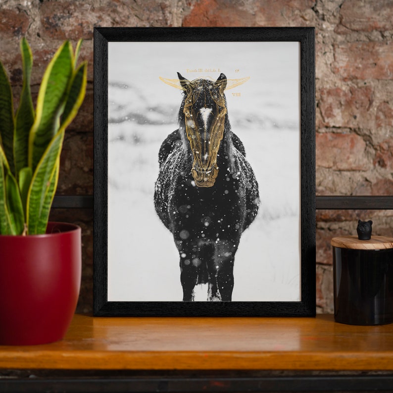 May include: A black and white framed print of a horse with a gold foil design. The horse is standing in a snowy field. The print has the text "Year of the Wild" and "VIII" in gold foil.
