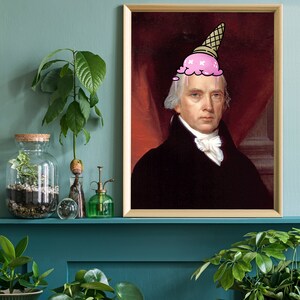 May include: A framed portrait of a man with a pink ice cream cone on his head. The man is wearing a black suit and a white shirt with a white collar. The background is a red and gold color.