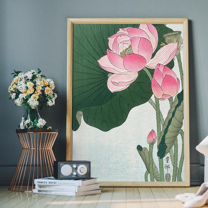 May include: A framed print of a pink and green lotus flower with a green leaf in the background. The print has a Japanese character in the bottom right corner.