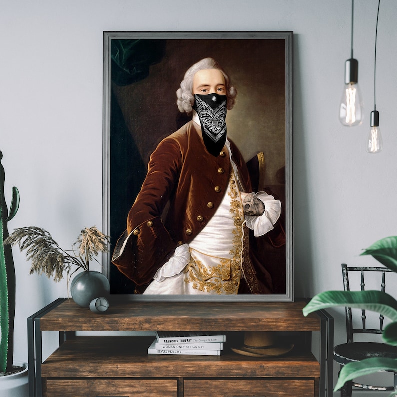 May include: A painting of a man in a brown velvet jacket and white shirt with gold embroidery. He is wearing a black bandana over his face. The painting is in a gold frame.