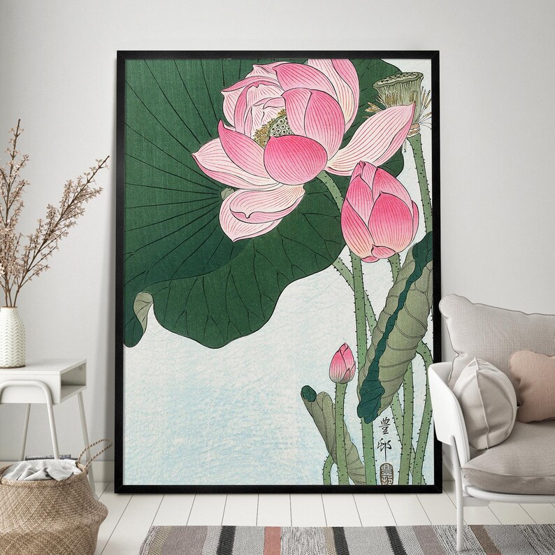 May include: A vintage Japanese woodblock print featuring pink lotus flowers with green leaves and stems. The print has a light blue background and includes Japanese text.