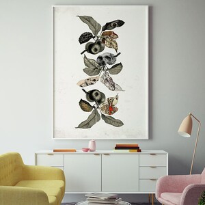 May include: A framed collage of a stylized apple tree with leaves, apples, and anatomical illustrations. The artwork is in black, white, and red tones and is displayed on a white wall above a white dresser.