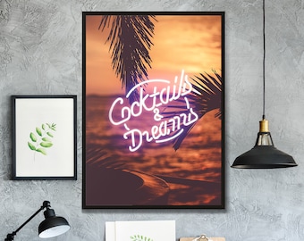 Op de afbeelding: Een ingelijst print met een zonsondergang achtergrond en palmbomen. De print heeft een neon-bord met de tekst "Cocktails & Dreams".