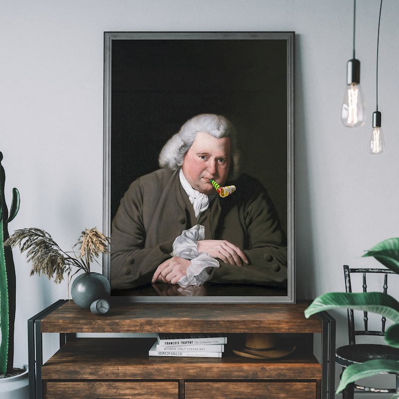May include: A framed portrait of a man in a dark brown jacket with a white shirt and a green and yellow party blower in his mouth. The portrait is set against a dark background.