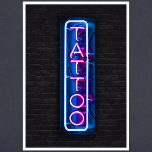 May include: A neon sign with the word "TATTOO" in pink letters on a blue background. The sign is mounted on a brick wall.