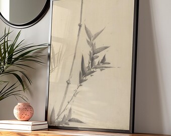 Puede incluir: Arte de pared enmarcado en negro con un dibujo minimalista en tinta negra y blanca de hojas y tallos de bambú sobre un fondo crema.