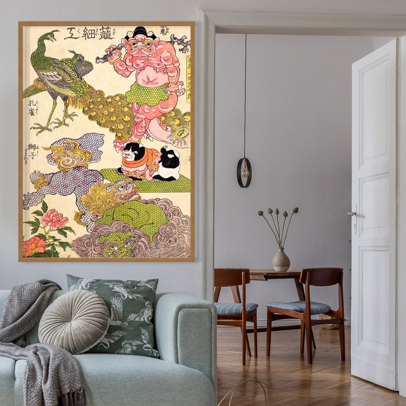 Op de afbeelding: Een vintage Japanse houtsnede die een kleurrijke sc&egrave;ne afbeeldt met een grote, roze, mensachtige figuur met een kroon en een pauw. De print is ingelijst in een houten lijst.