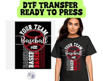 May include: A black t-shirt with a red and white baseball graphic and the text "Your Team Baseball #22". The graphic features a baseball with red stitching and a white outline. The text is in a white cursive font. The shirt is ready to press.
