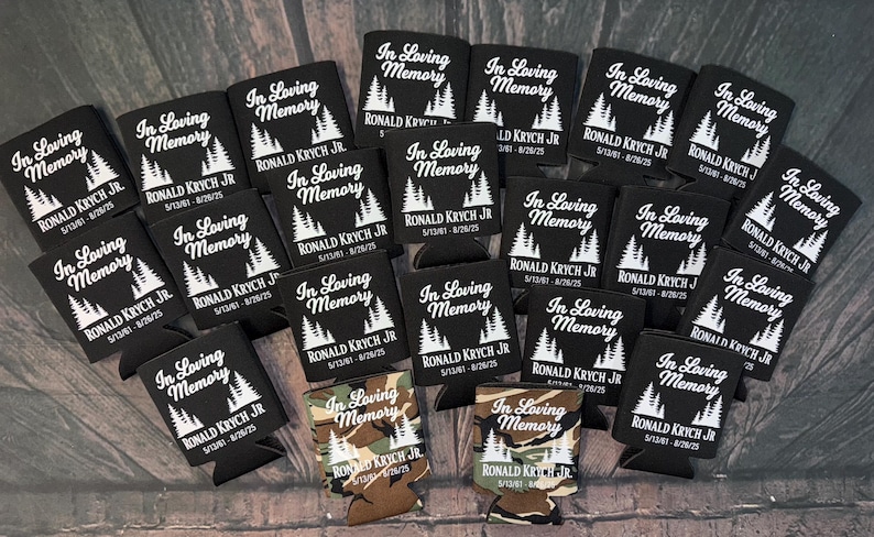 May include: A collection of black can coolers with the text "In Loving Memory" and the name "RONALD KRYCH JR" printed in white. The coolers also feature a tree graphic and dates.