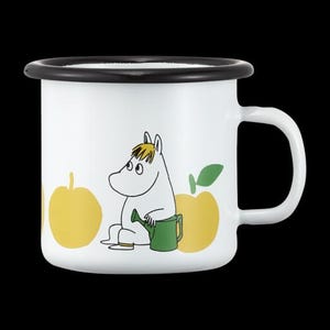 May include: White enamel mug with a black rim and handle. The mug features a cartoon character with yellow hair, sitting next to a green watering can and yellow apples. A charming and whimsical design.
