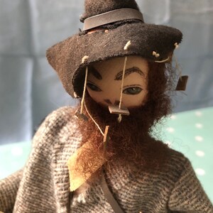 Vintage Australische Swagman Puppe sitzend auf Holzstamm