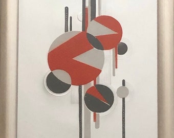 May include: Abstract art print in a silver frame. The artwork features geometric shapes, including circles and lines, in red, gray, and black against a white background. The design has a modern, minimalist aesthetic.