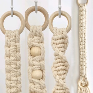 May include: Three variations of a macrame wall hanging with wooden rings. The first hanging has a simple knot pattern, the second has wooden beads, and the third has a more intricate knot pattern.
