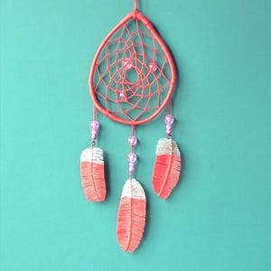 Atrapasueños rosa tejido a mano para colgar en la pared con plumas de macramé hechas a mano.