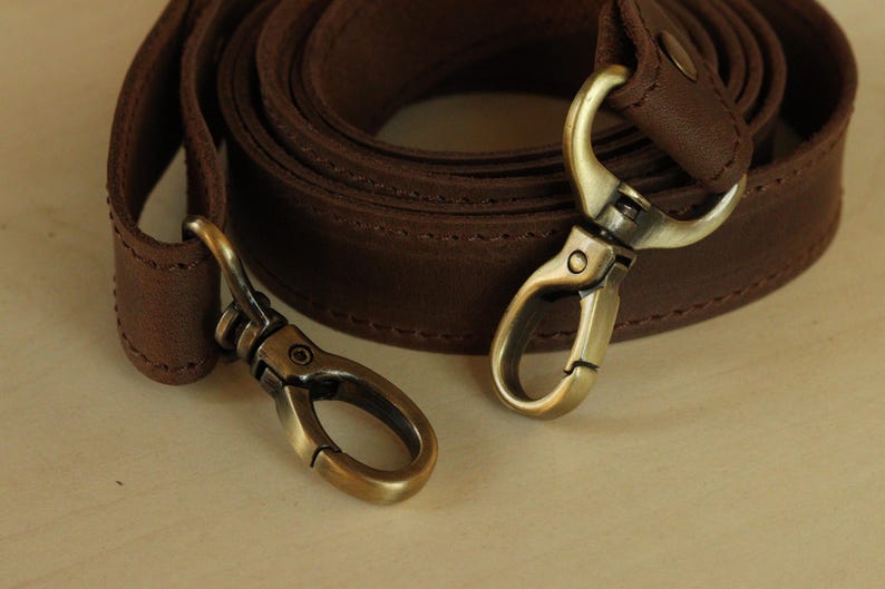 Genuine Leather Shoulder Strap with Swivel Hooks, Removable Crossbody Strap, Rotating Clasp Strap, Detachable Adjustable Leather Crossbody Strap: Antique Brass Swivel Hooks, 1" wide
 
 This wide strap is made of high quality genuine Crazy Horse leather. It is durable and reliable, and has a matte fine grain finish that takes on a vintage look over time.
Maximum length (from carabiners):53.15 inches
Minimum length (from carabiners): 25.6 inches
Width: 0.56 inches
