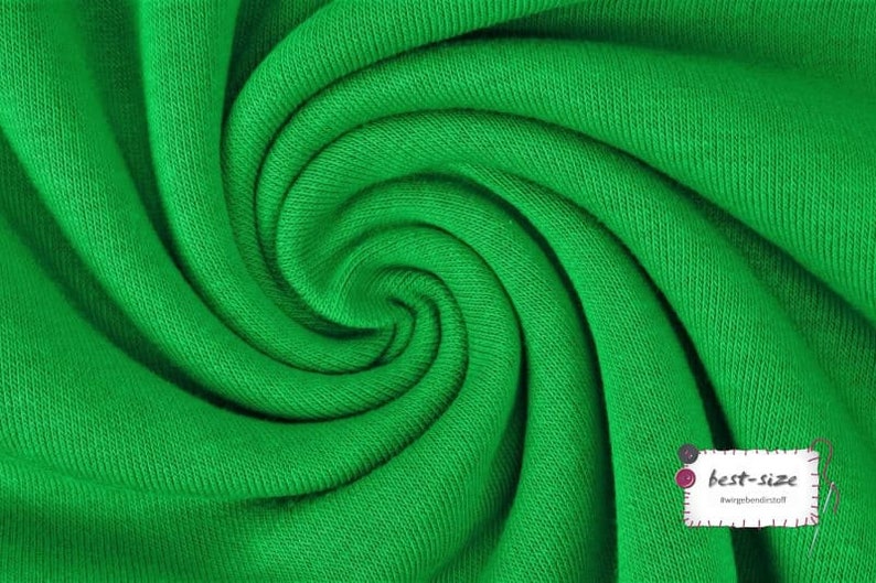 May include: Close-up of a bright green fabric with a textured surface. The fabric is folded and twisted, creating a swirling pattern.