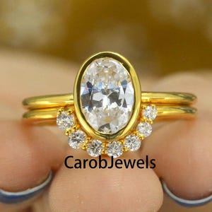 Solitaire 10x7 MM Bezel Set Oval Cut Colorless Moissanite Engagement Ring, Matching Round Moissanite Band, 10k Yellow Gold Bridal Ring Set