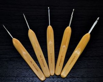 May include: Set of six bamboo crochet hooks with different sizes. The hooks are made of natural bamboo and have a smooth finish. The sizes are marked on the hooks in millimeters.