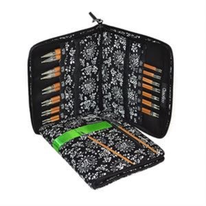 May include: A black zippered case with a white floral pattern holds a set of interchangeable knitting needles. The case is open and the needles are visible. The needles are made of bamboo and have a natural finish.