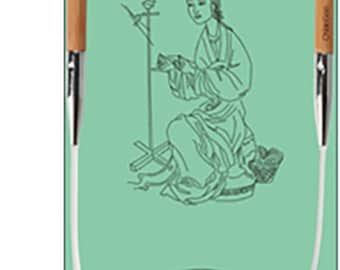 May include: Circular knitting needles with wooden tips and a flexible white cable. The needles are displayed against a light green background with a drawing of a woman weaving. The packaging also includes Chinese characters.