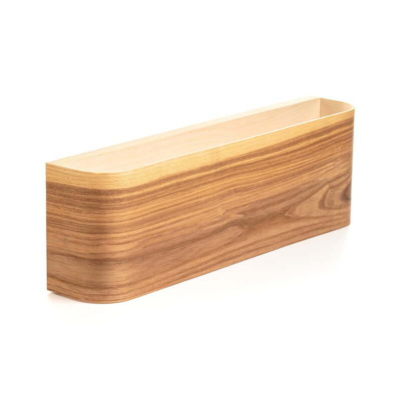 May include: A wooden wall shelf with a curved front edge. The shelf is made of light brown wood with a natural wood grain pattern.