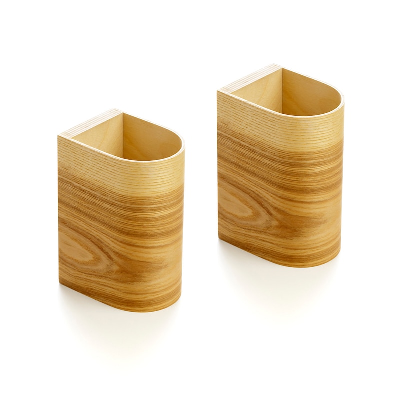 May include: Two wooden wall mounted organizers with a rounded front and a rectangular back. The organizers are made of light brown wood with a wood grain pattern.