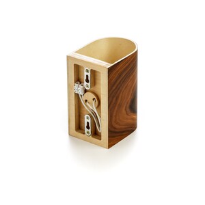 May include: A wooden wall sconce with a brown wood finish. The sconce has a white wire coming out of the back and a white electrical box with three white wire connectors. The sconce is designed to be mounted on a wall.