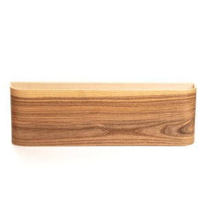 May include: A wooden wall shelf with a rounded edge and a natural wood grain finish.