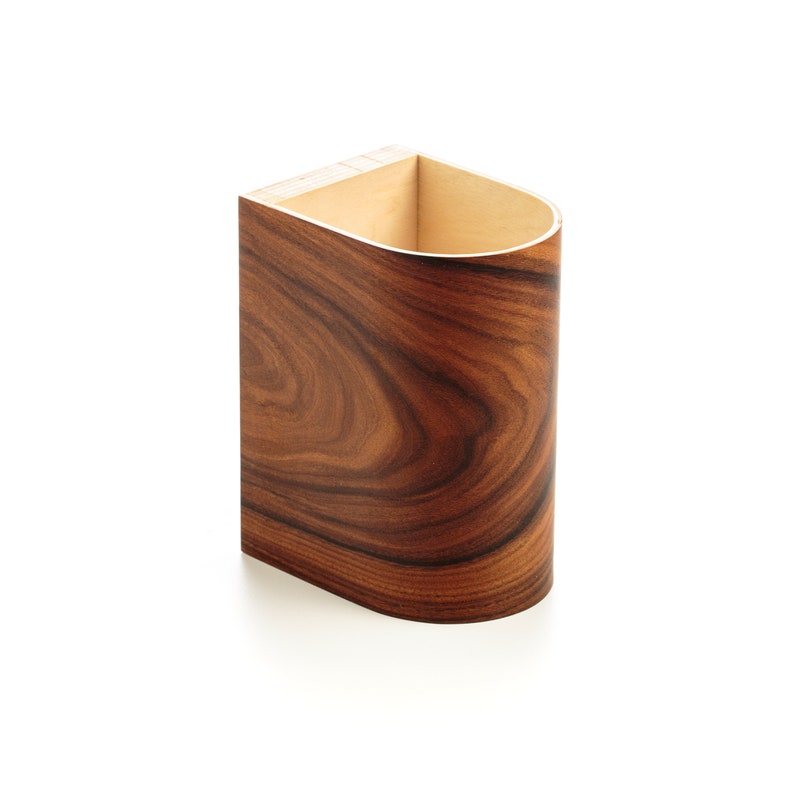 May include: A wooden container with a curved front and a light brown interior. The container is made of wood with a dark brown wood grain pattern.