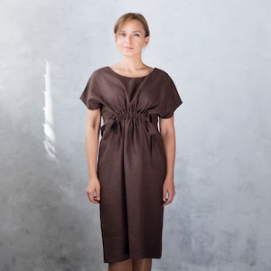 May include: A brown linen dress with a cinched waist and short sleeves.