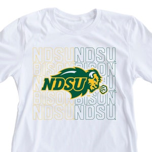 May include: White t-shirt with a green and yellow NDSU Bison logo and the words "NDSU" and "Bison" repeated in a stacked pattern.